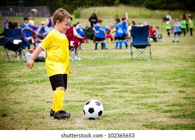 Young child boy playing soccer during organized league game