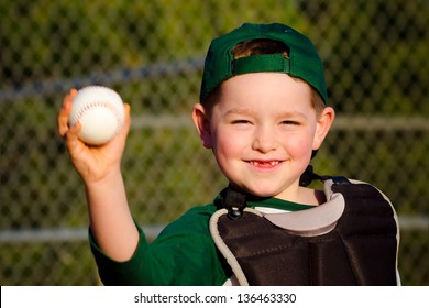 Young child in catcher's gear throwing baseball