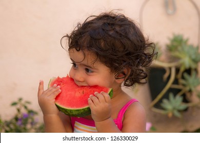 Young Child Eating Watermelon In Summer