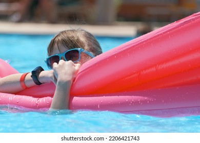 Young Child Girl Falling In Water From Inflatable Air Mattress In Swimming Pool While Swinnimg During Tropical Vacations. Safety Of Aquatic Activities Concept