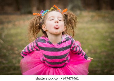 Young child girl making faces with crazy hair