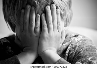 Young Child With His Head In His Hands Crying