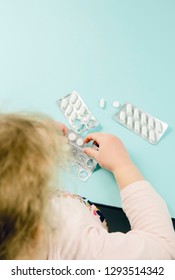 Young Child Play Alone With Pills Tablets At Home.  Keep Away From Children Reach Concept. No Medicine Cabinet, Raise Awareness.
