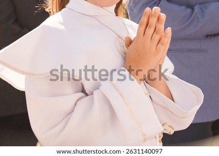 A young child prays while receiving a sacrament during a Catholic church service. A moment of personal faith, silence, and sacred connection in religious tradition.