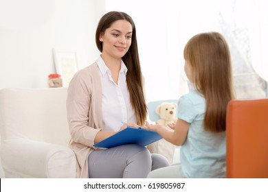 Young Child Psychologist Working With Little Girl