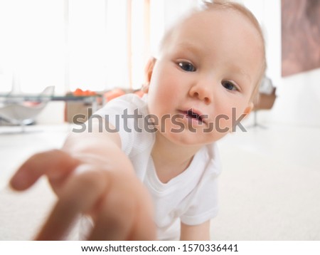 Image, Stock Photo Blond, interested, curious child in a blue striped shirt, at home in front of a bright window with light, looks into the camera. Gobble-eyed, sweet tooth watches, spellbound, expectant the family. Dreamy toddler dreams daydream