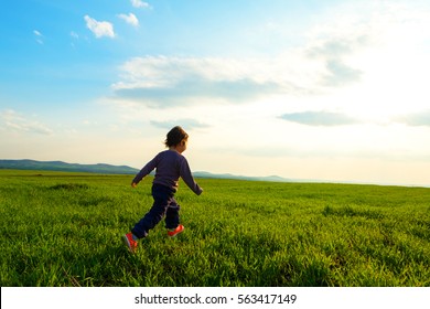 Young Child Running Through A Meadow