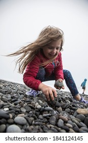 Young Child Searches For Skipping Rocks