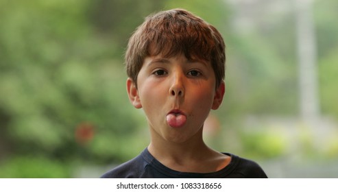 Young Child Sticking Tongue Out Misbehaving. Disobedient Kid Sticks Tongue Out To Camera