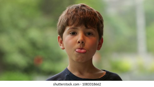 Young Child Sticking Tongue Out Misbehaving. Disobedient Kid Sticks Tongue Out To Camera