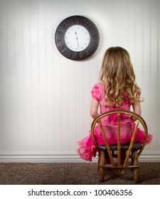 A Young Child In Time Out Or In Trouble, With Clock On Wall