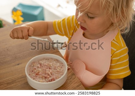 Similar – Image, Stock Photo Young child savoring a blue lollipop enthusiastically