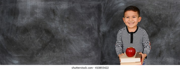 Young child who is standing with a chalkboard