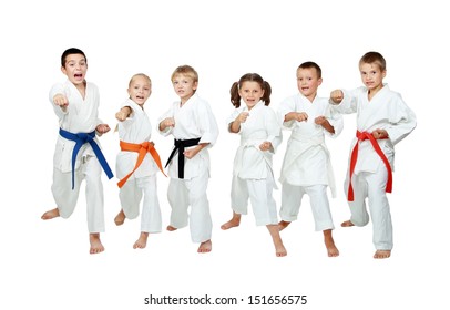 Young children in kimono perform techniques karate on a white background