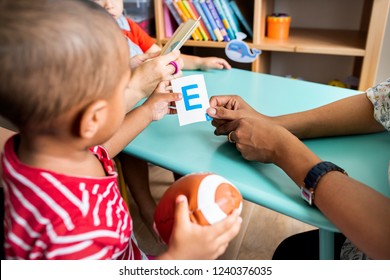 Young Children Learning The English Alphabet With Their Parents