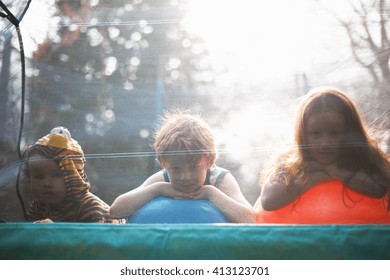 Young children looking out from garden trampoline - Powered by Shutterstock