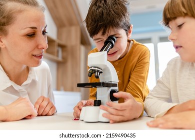 
Young Children Looking Through The Microscope Doing Science Project In School . STEM In Education Concept.