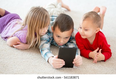 Young children playing games with computer tablet. - Shutterstock ID 561183871