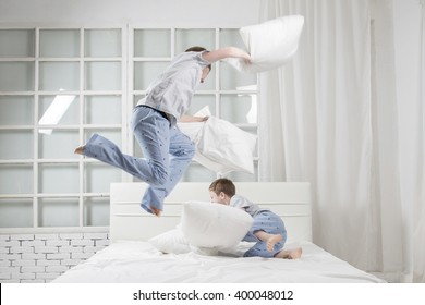 Young Children Playing On The Bed. Pillow Fight