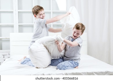 Young Children Playing On The Bed. Pillow Fight