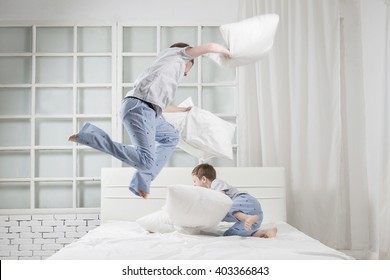 Young Children Playing On The Bed. Pillow Fight