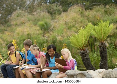 Young Children Preparing Notes On Clipboards During Field Trip