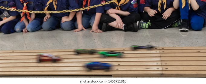 Young children racing pinewood cars action shot