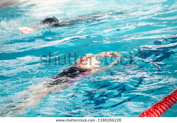 小道でプールで背泳ぎをする幼い子どもたち の写真素材 今すぐ編集