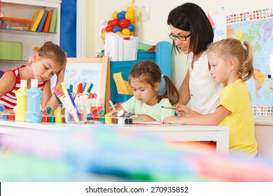 young children with teacher draw in the classroom