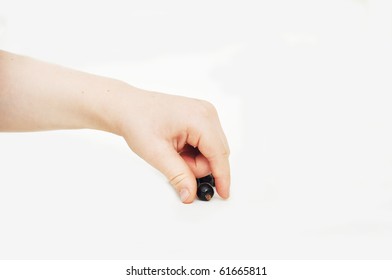 Young Child's Hand Picking Up A Berry