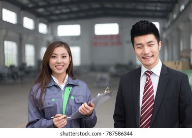 young chinese businessman and woman work in motor manufacturing factory - Shutterstock ID 787586344