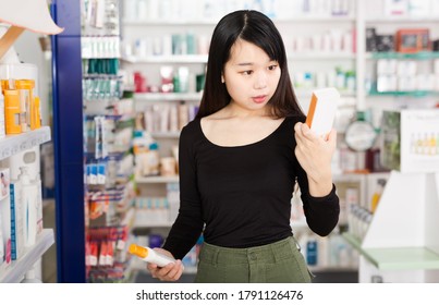 薬屋で薬を選ぶ中国の若い女性客