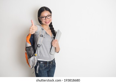  Young Chinese Female Student With Thumbs Up And Plain Background