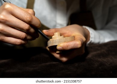 young Chinese female violin maker working with gouge to making a new violin in her workshop - Powered by Shutterstock