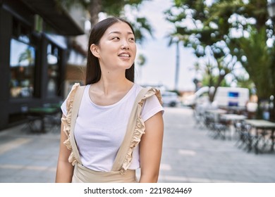 Young Chinese Girl Smiling Happy Standing At The City.