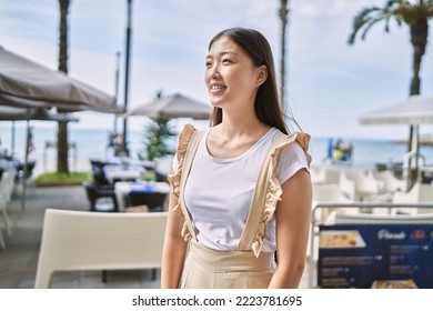 Young Chinese Girl Smiling Happy Standing At The Beach.