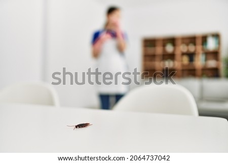 Young chinese housewife looking cockroach on the table at home.