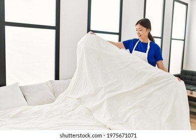 Young Chinese Housewife Make Bed At Home.
