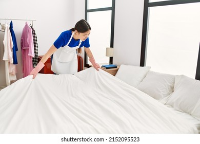 Young Chinese Housewife Make Bed At Home.