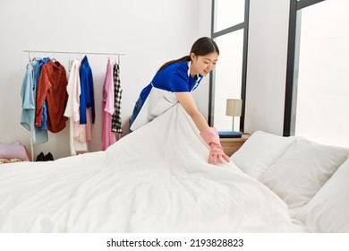 Young Chinese Housewife Make Bed At Home.