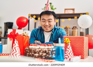 Young Chinese Man Celebrating Birthday Sitting On Table At Home