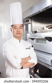 Young Chinese Man Chef In Modern Kitchen