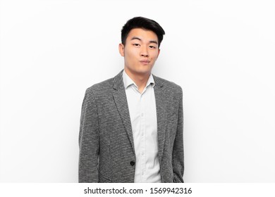 young chinese man and goofy  crazy  surprised expression  puffing cheeks  feeling stuffed  fat   full food against flat color wall