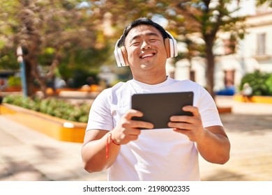 Young Chinese Man Smiling Confident Watching Video At Park