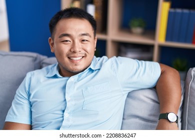 Young Chinese Man Smiling Confident Sitting On Sofa At Home