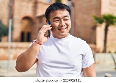 Young Chinese Man Smiling Confident Talking On The Smartphone At Street