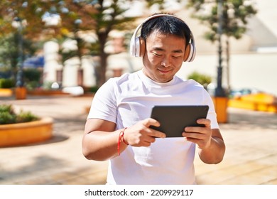 Young Chinese Man Smiling Confident Watching Video At Park