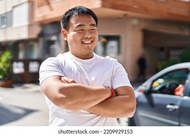 Young Chinese Man Smiling Confident Standing With Arms Crossed Gesture At Street