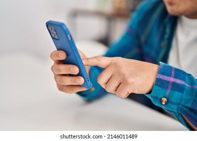 Young Chinese Man Using Smartphone Sitting On Table At Home