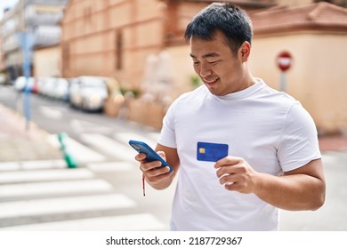 Young Chinese Man Using Smartphone And Credit Card At Street